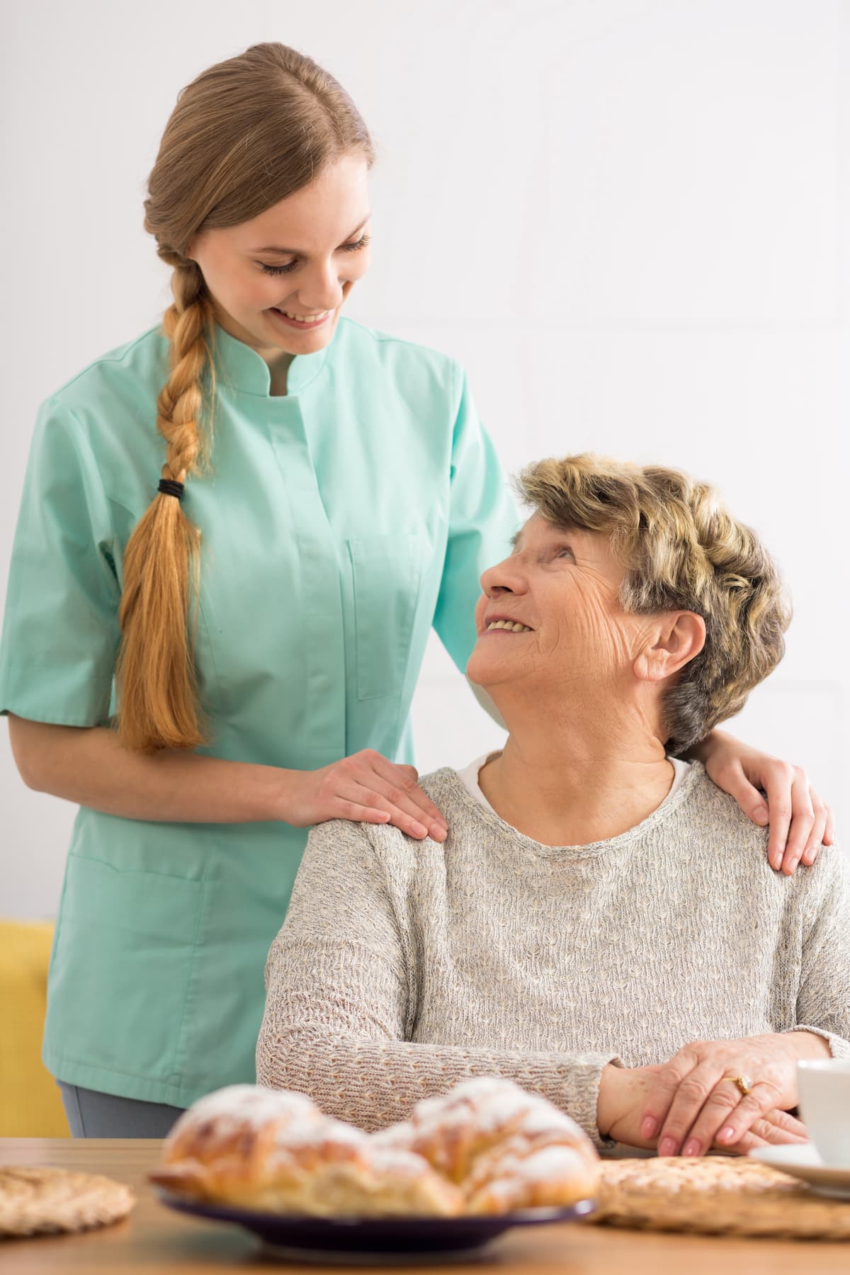 A Kirpa caregiver standing with a smiling senior woman at home